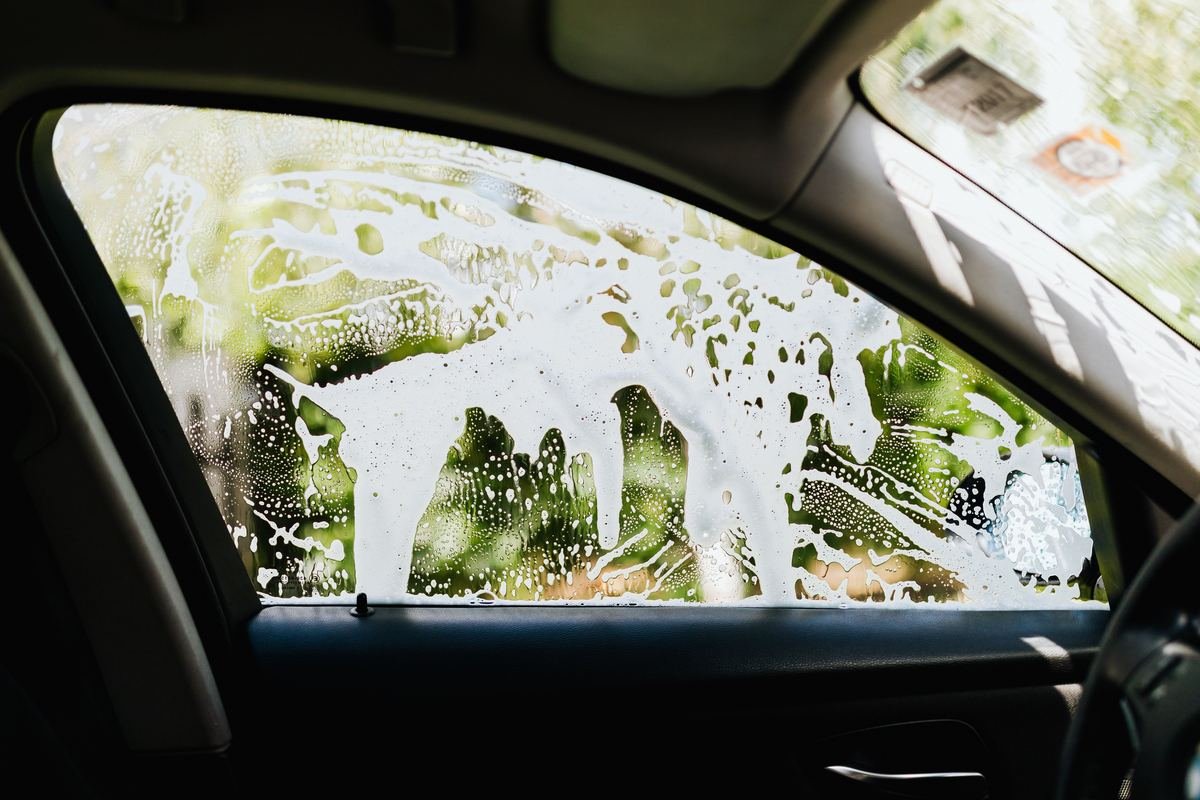 Le givre recouvre la vitre d'une voiture un matin d'hiver