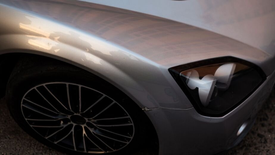 Aile avant froissee et pare-chocs desaligne sur une voiture grise avant remise en etat carrosserie